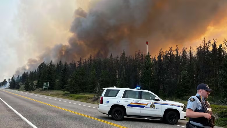 Hundreds of uncontrolled wildfires burned across western Canada on Wednesday, putting more communities under evacuation alert and raising concerns about the blazes impacting Canadian crude production.
