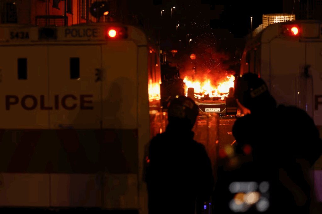 Hundreds of masked rioters attacked police and set homes and cars on fire in the Northern Irish town of Ballymena.