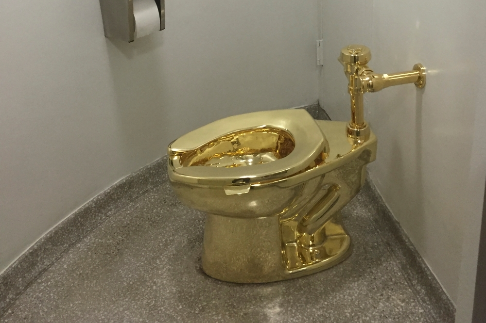 Two men were jailed for stealing an 18-carat golden toilet that had been on display in an exhibition at Winston Churchill's birthplace.
