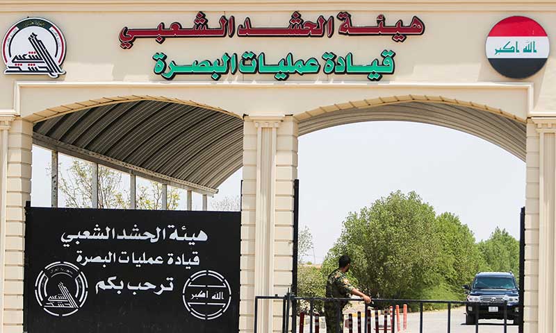 A vehicle approaches a gate at the Basra Operations Command headquarters, following airstrikes that the PMF said were carried out by U.S. and Saudi forces in Basra