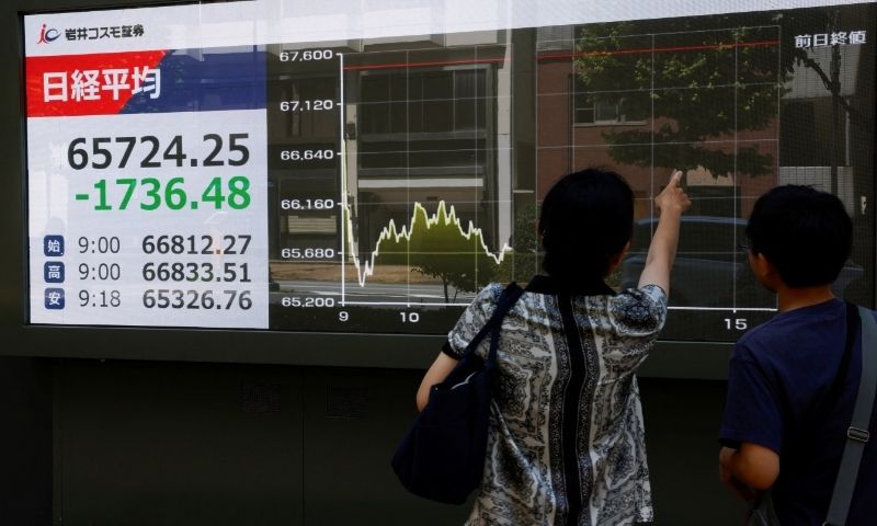 People look at a stock quotation board displaying the Nikkei share average, outside a brokerage in Tokyo, Japan, August 19, 2026. REUTERS/Manami Yamada