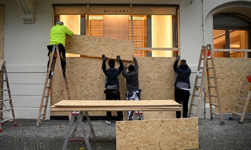 Workers secure a Bvlgari store with wooden boards ahead of expected protests by the youth movement 