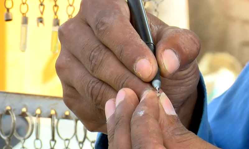 دومنٹ میں چاول کے دانے پر نام لکھنے والا نوجوان